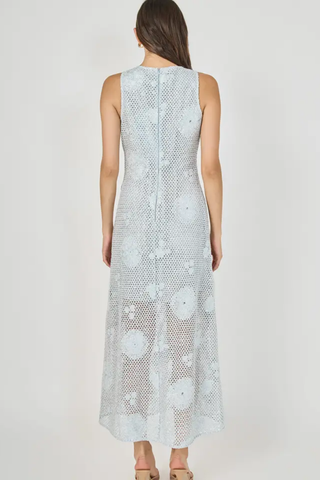 Woman wearing a light blue floral dress on a white background