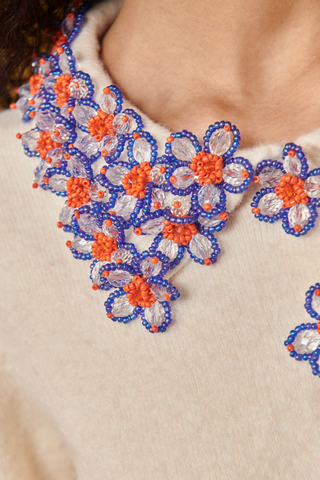 Celia B Bloom Cardigan in cream with colorful blue and orange floral embellishments along the neckline and front.