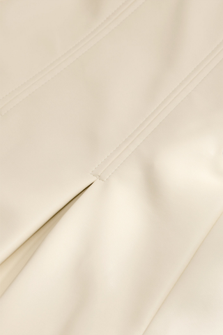 Faith Skirt in Polar featuring a cream vegan leather midi silhouette with a fitted waist and inverted box pleats.
