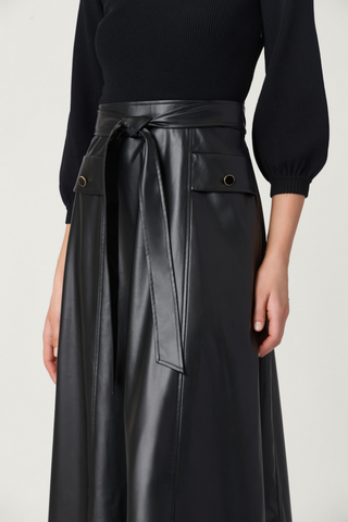 Shoshanna Aspen Dress in Jet featuring a fitted black knit bodice, three-quarter balloon sleeves, faux leather A-line midi skirt, and tie waist.