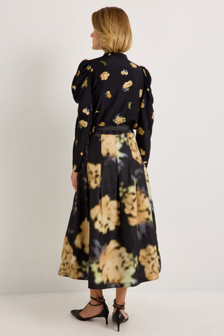 Marie Oliver Faith Skirt in Lush featuring a black and yellow abstract floral print, feminine box pleats, and flowing midi silhouette.