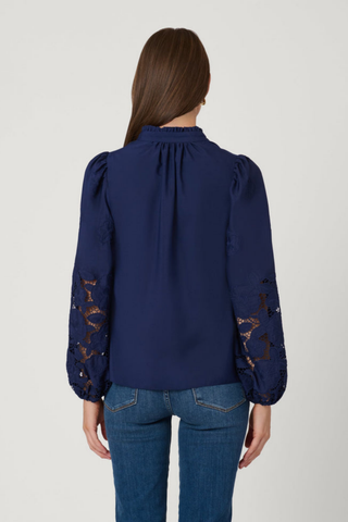 Model wearing the Shoshanna Ingrid Top in Navy featuring embroidered sleeves, a ruffle neckline, and relaxed fit.