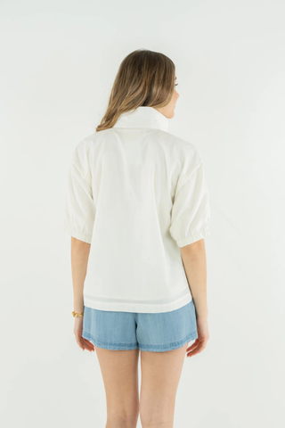 Woman wearing a white sweater and light blue shorts on a white background