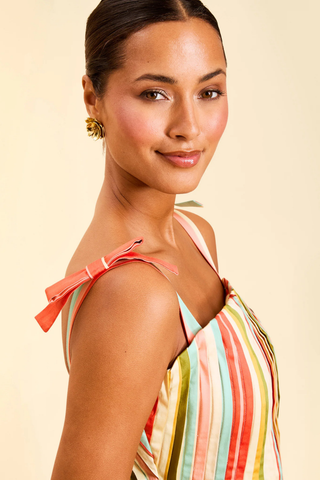 Model wearing Mestiza Anais Pintuck Midi Dress in Paradise Stripe featuring a pintucked bodice, bow straps, and colorful striped midi silhouette