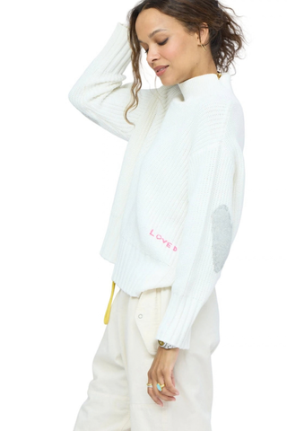 Kerri Rosenthal Marlow Imperfect Heart Sweater in Natural featuring a soft ivory rib knit, mock neck, and contrast heart elbow patches.