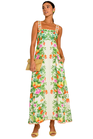 Model wearing the Elizabeth James Annalisa Dress in Tea Time, a colorful floral maxi dress with adjustable straps, a fitted bodice, scalloped embroidered trim, and a flowing silhouette.