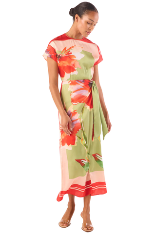 Model wearing the MISA Devorah Dress in Scarf Flora Satin featuring a vibrant floral print, satin fabric, side tie wrap detail, high neckline, and midi length silhouette
