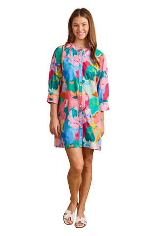 Model wearing the Double A Paloma Dress in Bougainville featuring a colorful watercolor floral print, button-front styling, three-quarter sleeves, and a relaxed mini silhouette