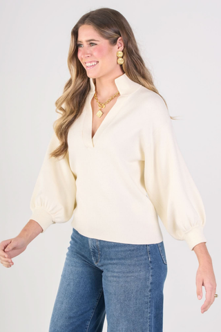 Emily McCarthy Lolli Sweater in Sandshell, a cream long sleeve sweater with a stand collar, V-neckline, and blouson sleeves.