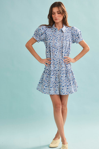 Woman wearing a floral dress against a light blue background