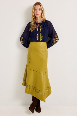 Marie Oliver Royce Blouse in Sundown featuring deep navy fabric, colorful embroidery, a tie neckline, and billowy sleeves.