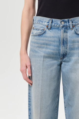 Model wearing AGOLDE The 80’s Jean in Orbital, a high-rise straight-leg rigid denim jean in a medium vintage indigo wash