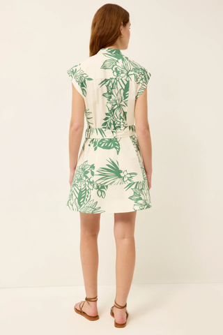Woman wearing a white dress with green leaf pattern on a white background