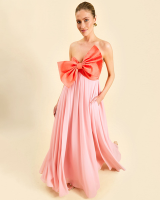 Mestiza Kiss Me Knot Gown in Bloom Pink featuring a strapless chiffon silhouette with an oversized statement bow and flowing skirt.
