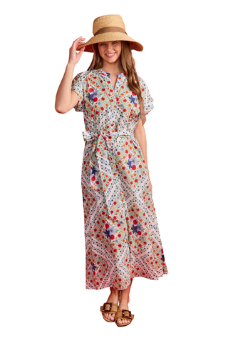 Woman wearing a floral dress and wide-brimmed hat on a white background
