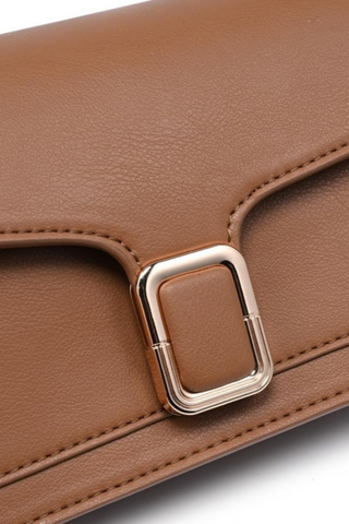 Urban Expressions Coco Crossbody in Camel featuring smooth vegan leather, a structured flap silhouette, buckle detail, and adjustable strap.