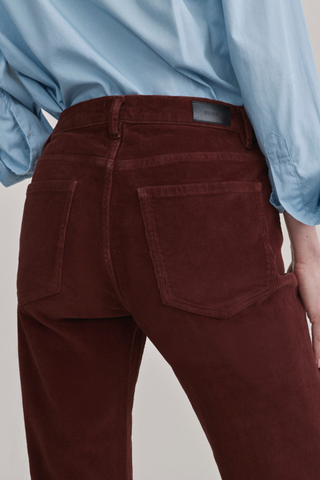 DL1961 Bella Slim Boot Jean in Syrah Cord featuring a mid-rise slim bootcut silhouette in muted red corduroy.