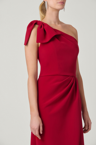 Shoshanna Killian Dress in Ruby featuring a one-shoulder neckline, statement bow, draped bodice, and full-length skirt with front slit.