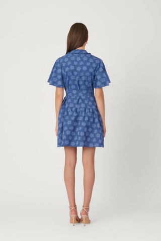 Model wearing the Shoshanna Lynn Dress in Steel Blue featuring flutter sleeves, a ruffle collar, self-tie waist, and gathered mini skirt.