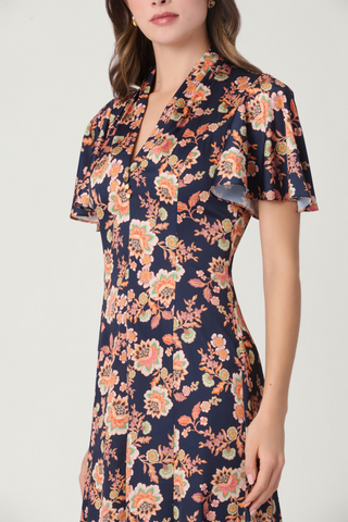 Shoshanna Cinnie Dress in Navy Multi featuring a floral satin print, draped V-neckline, flutter sleeves, gold-tone buttons, and asymmetrical hem.