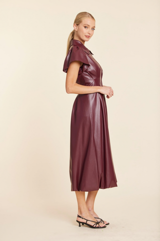 Dolce Cabo Long Maxi Bubble in Burgundy featuring faux leather, flutter sleeves, a pointed collar, structured waist, and long bubble-hem silhouette.