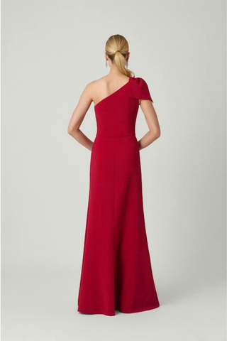 Shoshanna Killian Dress in Ruby featuring a one-shoulder neckline, statement bow, draped bodice, and full-length skirt with front slit.