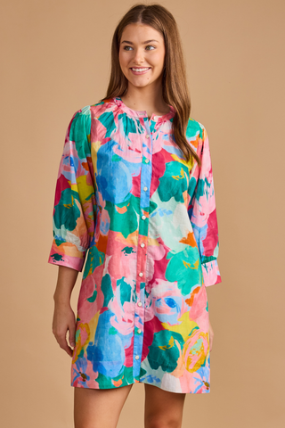Model wearing the Double A Paloma Dress in Bougainville featuring a colorful watercolor floral print, button-front styling, three-quarter sleeves, and a relaxed mini silhouette