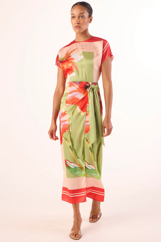 Model wearing the MISA Devorah Dress in Scarf Flora Satin featuring a vibrant floral print, satin fabric, side tie wrap detail, high neckline, and midi length silhouette