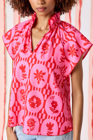 Model wearing Crosby Wilkes Top in Parterre Floral featuring pink and red floral print, flutter sleeves, and a ruffled mock neckline