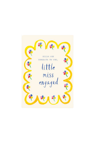 A rectangular greeting card with a cream background, featuring a yellow scalloped border decorated with small colorful flowers. The text reads 'HELLO AND CONGRATS TO YOU, little miss engaged' in blue and black lettering.