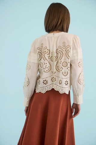 Ivory embroidered cotton eyelet blouse with long sleeves.