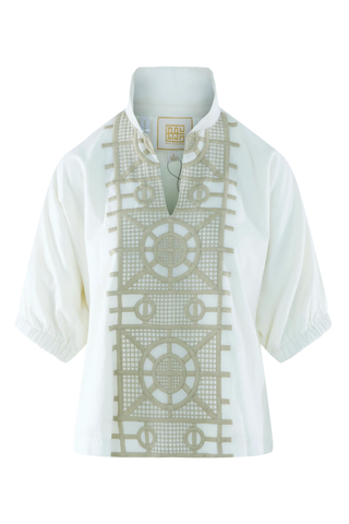 White shirt with intricate beige embroidery on a mannequin against a white background