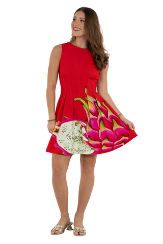 Model wearing the Emily McCarthy Vivi Dress in Dragon Fruit featuring a bright red colorway, sleeveless silhouette, flared skirt, and oversized dragon fruit print detail