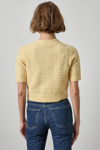 Woman wearing the Lilla P Short Sleeve Crewneck Cardigan in Buttercream, a pale yellow button-front knit cardigan.
