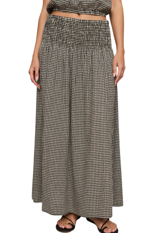 Model wearing the Z Supply Brooke Gingham Skirt in Black with a flowy maxi silhouette and smocked waistband.