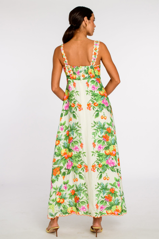 Model wearing the Elizabeth James Annalisa Dress in Tea Time, a colorful floral maxi dress with adjustable straps, a fitted bodice, scalloped embroidered trim, and a flowing silhouette.