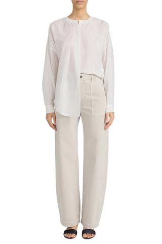 Model wearing FRAME The Bow Cargo in Flax, a high-rise barrel-leg cotton pant with oversized front cargo pockets in a neutral flax wash