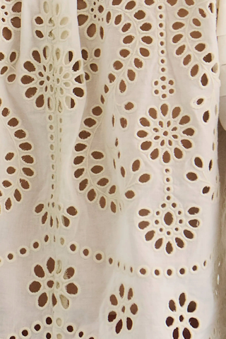 Ivory embroidered cotton eyelet blouse with long sleeves.