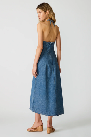 Woman wearing a blue denim dress on a white background