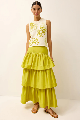 Model wearing the Marie Oliver Natasha Top in Lumino, a cream sleeveless knit sweater featuring oversized yellow floral embroidery, ribbed trim, a crew neckline, and a relaxed cropped fit.