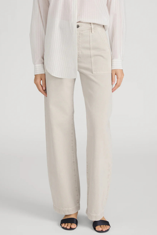 Model wearing FRAME The Bow Cargo in Flax, a high-rise barrel-leg cotton pant with oversized front cargo pockets in a neutral flax wash
