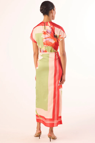 Model wearing the MISA Devorah Dress in Scarf Flora Satin featuring a vibrant floral print, satin fabric, side tie wrap detail, high neckline, and midi length silhouette