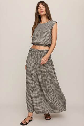 Model wearing the Z Supply Brooke Gingham Skirt in Black with a flowy maxi silhouette and smocked waistband.