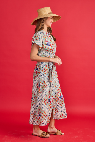 Woman wearing a floral dress and straw hat on a red background