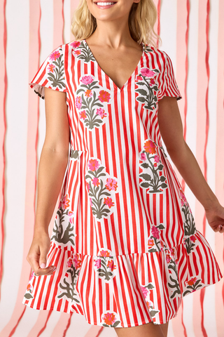 Model wearing Crosby Phoebe Dress in Garden Parasol featuring red stripe print, floral motifs, flutter sleeves, and a flounced mini silhouette