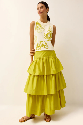 Model wearing the Marie Oliver Natasha Top in Lumino, a cream sleeveless knit sweater featuring oversized yellow floral embroidery, ribbed trim, a crew neckline, and a relaxed cropped fit.