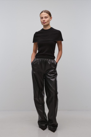 Black cape-style top with a modern tailored silhouette.