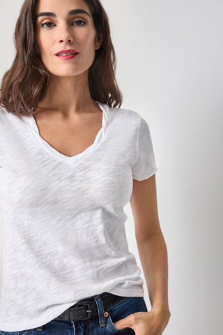 Model wearing the Lilla P Twisted Binding V-Neck Tee in White featuring lightweight textured slub cotton, a twisted V-neckline, and a flattering fitted silhouette.