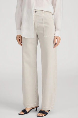 Model wearing FRAME The Bow Cargo in Flax, a high-rise barrel-leg cotton pant with oversized front cargo pockets in a neutral flax wash