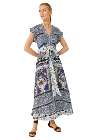Woman wearing a long, patterned dress on a white background